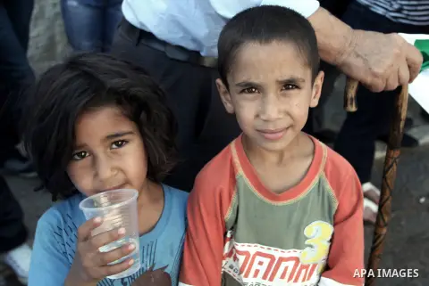 Palestinian children take part in a protest against the Israeli offensive on Gaza Strip, outside the Red Cross headquarter in east Jerusalem's Sheikh Jarrah neighborhood on August 07, 2014, while diplomatic efforts enter...