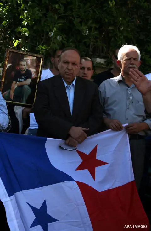 Palestinian protesters hold the flag of Panama during a protest against the Israeli offensive on Gaza Strip, outside the Red Cross headquarter in east Jerusalem's Sheikh Jarrah neighborhood on August 07, 2014, while dipl...
