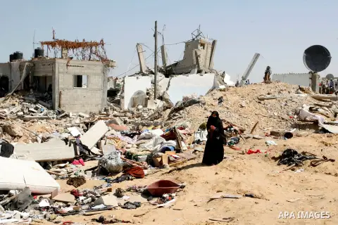 A Palestinian woman searches in her destroyed house which was hit in an Israeli air strike on Abasan, east of the southern Gaza Strip town of Khan Yunis and close to the border with Israel on August 7, 2014. Several peop...
