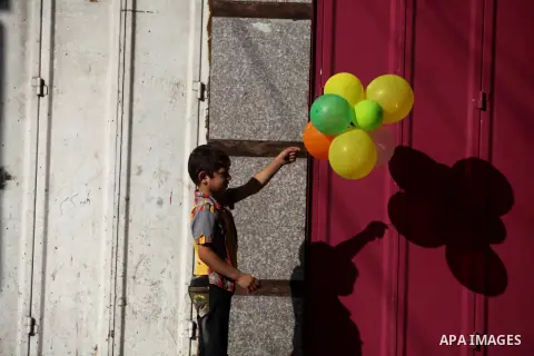 A Palestinian boy plays with ballons as families leave their homes in Gaza City's Shejaiya neighborhood in fear of Israeli attacks, after Palestinian factions in Gaza refused to extend the 72-hour ceasefire with Israel,...