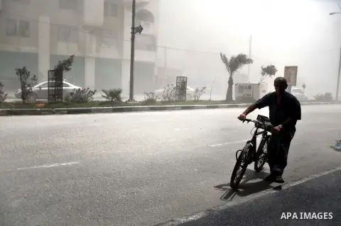 A Palestinian man walks in a street as smoke rises following what witnesses said was an Israeli air strike in Gaza City August 9, 2014. Israel launched more than 20 aerial attacks in Gaza early on Saturday and militants...