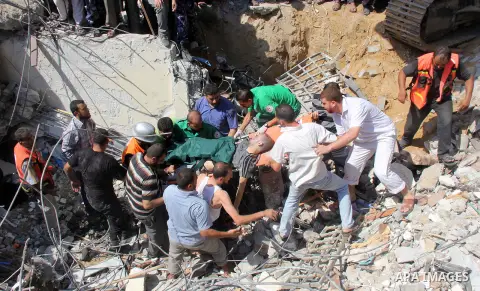 Rescue workers try to evacuate a Palestinian man from under the rubble of the al-Qassam mosque, which witnesses said was hit by an Israeli air strike, in Nuseirat refugee camp in the central Gaza Strip on August 9, 2014....