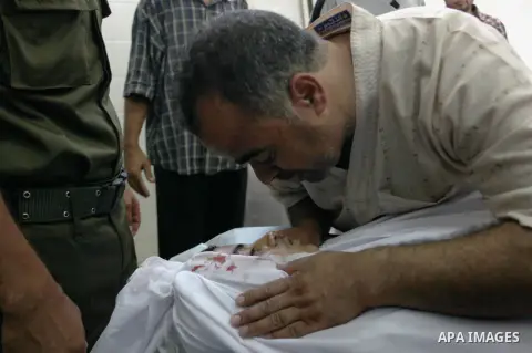 Palestinian relatives mourn arround the body of Ahmed Al-Masri, 14, who witnesses said was killed in an Israeli airstrike, at the morgue of al-Aqsa hospital in Deir Al-Balah town in Central Gaza Strip, August 10, 2014. P...