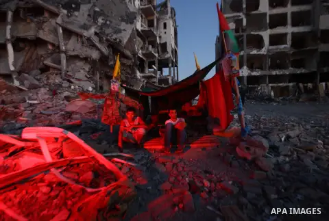 Palestinian sit in a tent outside houses, which witnesses said were destroyed in an Israeli offensive, during a 72-hour truce in Beit Lahiya town in the northern Gaza Strip August 12, 2014. Talks to end a month-long war...