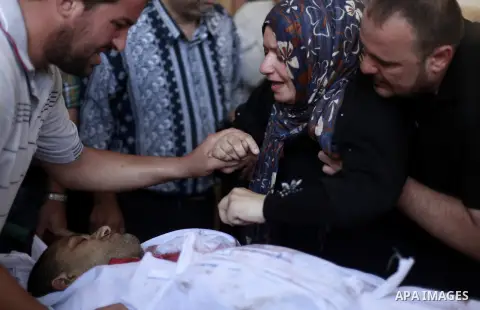 Relatives and friends mourn over the body of Ali Shehada Abu Afash, translator working with The Associated Press, during his funeral in Gaza City on August 13, 2014. Afash was killed in an ordnance explosion in the Gaza...