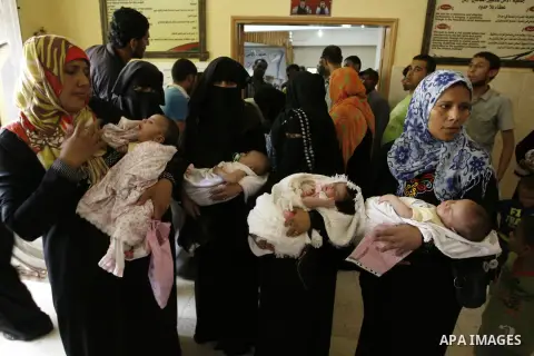 Displaced Palestinian women hold their babies, who had been born in shelters during the Israeli offensive, during a ceremony to honor the mothers in an UNRWA center in Rafah in southern Gaza Strip, August 13, 2014. The P...