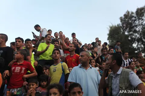 Palestinians celebrate during the wedding ceremony of a displaced couple at a United Nations-run school sheltering displaced Palestinians from the Israeli offensive, in Shati refugee camp in Gaza City August 13, 2014. Th...