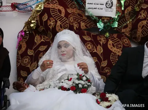 A Palestinian couple celebrate their wedding ceremony at a United Nations-run school sheltering displaced Palestinians from the Israeli offensive, in Shati refugee camp in Gaza City August 13, 2014. The threat of renewed...