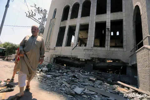 Palestinian worshipers perform Friday prayers next to the remains of a mosque which witnesses said was destroyed by an Israel air strike during the offensive, on the second day of a five-day ceasefire in Gaza City August...