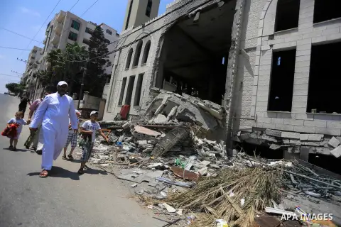 Palestinian worshipers perform Friday prayers next to the remains of a mosque which witnesses said was destroyed by an Israel air strike during the offensive, on the second day of a five-day ceasefire in Gaza City August...