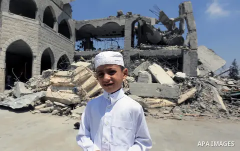 Palestinian worshipers perform Friday prayers next to the remains of a mosque which witnesses said was destroyed by an Israel air strike during the offensive, on the second day of a five-day ceasefire in Gaza City August...
