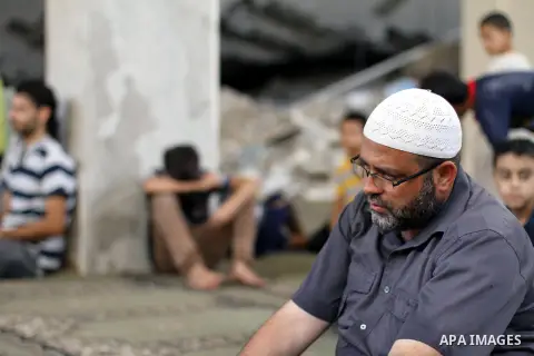 Palestinian worshipers perform Friday prayers next to the remains of a mosque which witnesses said was destroyed by an Israel air strike during the offensive, on the second day of a five-day ceasefire in Gaza City August...