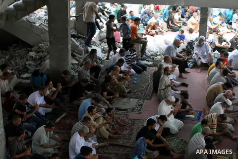 Palestinian worshipers perform Friday prayers next to the remains of a mosque which witnesses said was destroyed by an Israel air strike during the offensive, on the second day of a five-day ceasefire in Gaza City August...