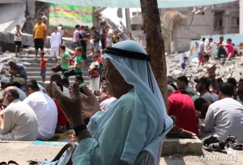 Palestinian worshipers perform Friday prayers next to the remains of a mosque which witnesses said was destroyed by an Israel air strike during the offensive, on the second day of a five-day ceasefire in Nuseirat refugee...