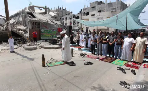 Unexploded shells that have been disarmed, which Palestinians say were fired by Israeli troops during the Israeli offensive, are placed by worshippers near themselves as they perform Friday prayers next to the remains of...