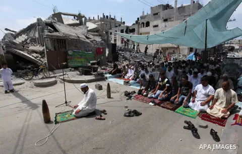 Unexploded shells that have been disarmed, which Palestinians say were fired by Israeli troops during the Israeli offensive, are placed by worshippers near themselves as they perform Friday prayers next to the remains of...