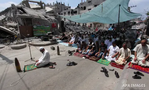 Unexploded shells that have been disarmed, which Palestinians say were fired by Israeli troops during the Israeli offensive, are placed by worshippers near themselves as they perform Friday prayers next to the remains of...