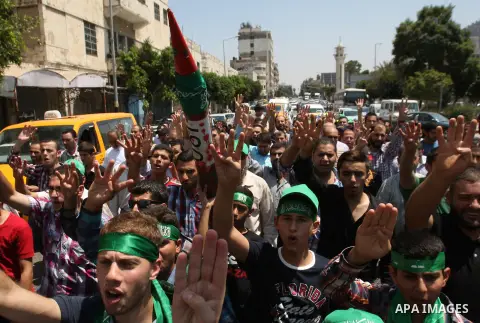 Palestinian protesters flash the Rabaa sign during a demonstration is support of Gaza after Friday prayers in the West Bank city of Nablus August 15, 2014. Two successive truces since Monday, expected to last through Aug...
