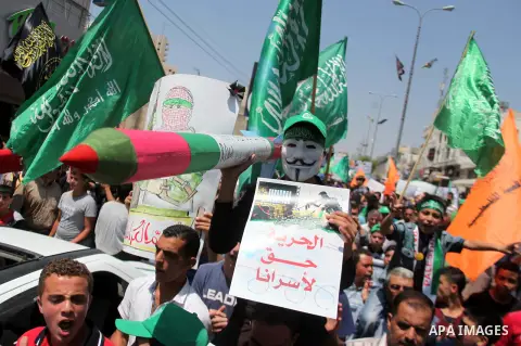 A Palestinian protester holds a mock rocket during a demonstration to support people in Gaza and Palestinian negotiators in Cairo, Egypt, in West Bank city of Hebron on Friday, Aug. 15, 2014. Israel and Palestinians are...