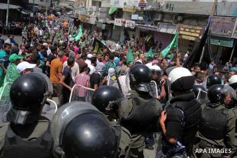 Palestinian security forces keep watch during a demonstration to support people in Gaza and Palestinian negotiators in Cairo, Egypt, in West Bank city of Hebron on Friday, Aug. 15, 2014. Israel and Hamas are observing a...