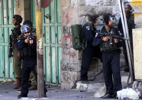 Israeli security forces take position during clashes with Palestinian protesters following a demonstration to support people in Gaza and Palestinian negotiators in Cairo, Egypt, in West Bank city of Hebron on Friday, Aug...