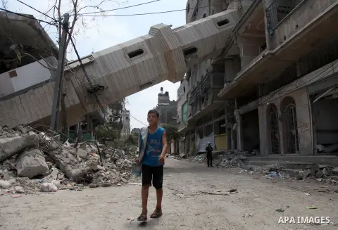 A Palestinian boy walks past a mosque which witnesses said was destroyed by an Israel air strike during the offensive, on the second day of a five-day ceasefire, in Gaza city on August 15, 2014. Israel and Palestinians a...