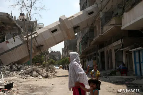 Palestinian children walk past a mosque which witnesses said was destroyed by an Israel air strike during the offensive, on the second day of a five-day ceasefire, in Gaza city on August 15, 2014. Israel and Palestinians...