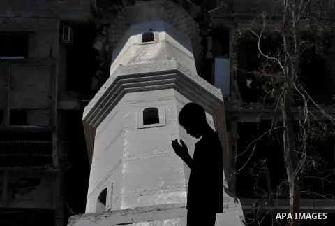 A Palestinian boy prays at a mosque which witnesses said was destroyed by an Israel air strike during the offensive, on the second day of a five-day ceasefire, in Gaza city on August 15, 2014. Israel and Palestinians are...