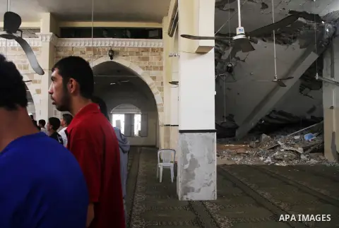 Palestinian worshipers perform Friday prayers next to the remains of a mosque which witnesses said was destroyed by an Israel air strike during the offensive, on the second day of a five-day ceasefire in Gaza City August...