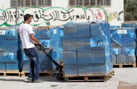 Palestinians carry aid supplies to be sent to the stricken in the Gaza Strip, in the West bank city of Ramallah on August 16, 2014. According to United Nations figures, around one quarter of a million people fled their h...