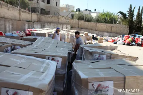 Palestinians carry aid supplies to be sent to the stricken in the Gaza Strip, in the West bank city of Ramallah on August 16, 2014. According to United Nations figures, around one quarter of a million people fled their h...