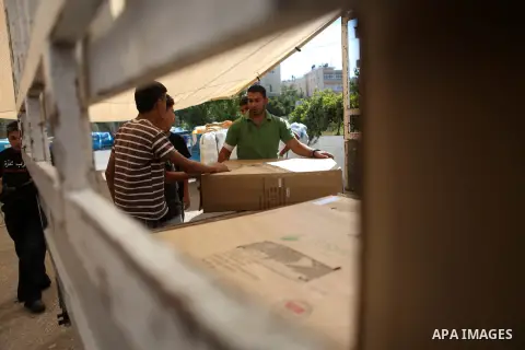 Palestinians carry aid supplies to be sent to the stricken in the Gaza Strip, in the West bank city of Ramallah on August 16, 2014. According to United Nations figures, around one quarter of a million people fled their h...