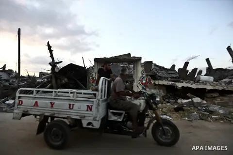 Palestinians walk front of rubble of apartment buildings destroyed during fighting between Hamas and Israel in the town of Beit Hanoun, in the northern Gaza Strip, on August 16, 2014. The United Nations estimates about 1...