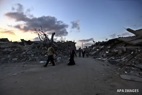 Palestinians walk front of rubble of apartment buildings destroyed during fighting between Hamas and Israel in the town of Beit Hanoun, in the northern Gaza Strip, on August 16, 2014. The United Nations estimates about 1...