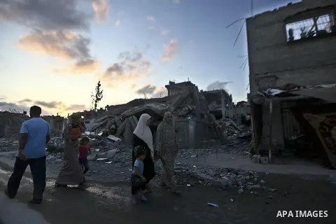 Palestinians walk front of rubble of apartment buildings destroyed during fighting between Hamas and Israel in the town of Beit Hanoun, in the northern Gaza Strip, on August 16, 2014. The United Nations estimates about 1...