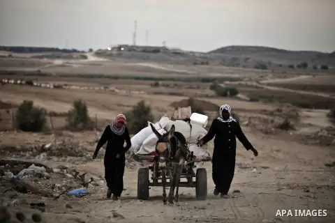 Palestinians walk front of rubble of apartment buildings destroyed during fighting between Hamas and Israel in the town of Beit Hanoun, in the northern Gaza Strip, on August 16, 2014. The United Nations estimates about 1...