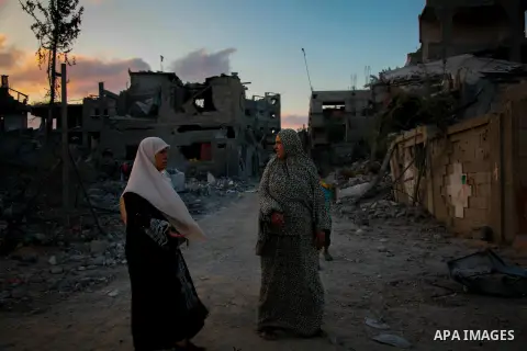 Palestinians walk past the rubble of apartment buildings destroyed during fighting between Hamas and Israel in the town of Beit Hanoun, in the northern Gaza Strip, on August 16, 2014. The United Nations estimates about 1...