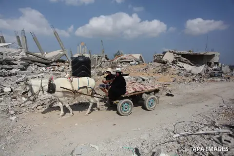 Palestinians ride a donkey cart past the ruins of houses which witnesses said was destroyed during the Israeli offensive in Johr El-Deek village near the central Gaza Strip August 17, 2014. Prime Minister Benjamin Netany...