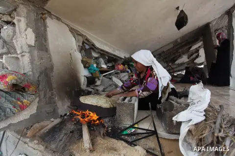 A Palestinian woman bakes bread on the rubble of her house which witnesses said was destroyed during the Israeli offensive in Johr El-Deek village near the central Gaza Strip August 17, 2014. Prime Minister Benjamin Neta...