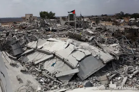 A Palestinian flag flutters as a boy walks amongst the ruins of a house which witnesses said was destroyed by an Israeli air strike during the offensive in Johr El-Deek village near the central Gaza Strip August 17, 2014...