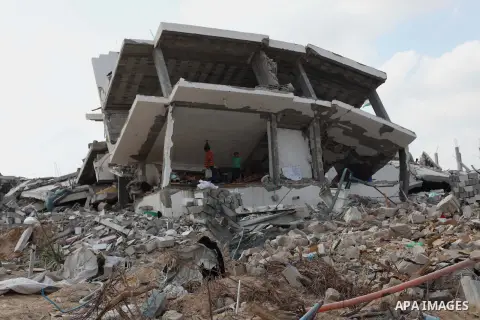 Palestinians stand at the remains of their house which witnesses said was destroyed during the Israeli offensive in Johr El-Deek village near the central Gaza Strip August 17, 2014. Prime Minister Benjamin Netanyahu said...