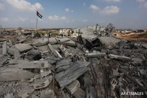 A Palestinian flag flutters as a boy walks amongst the ruins of a house which witnesses said was destroyed by an Israeli air strike during the offensive in Johr El-Deek village near the central Gaza Strip August 17, 2014...
