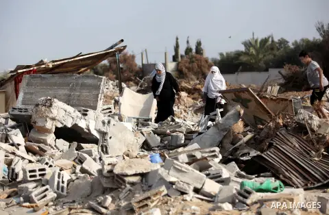 Palestinians inspect their destroyed houses, which witnesses said were damaged during the Israeli offensive, on the fourth day of a five-day ceasefire in Johr El-Deek village near the central Gaza Strip August 17, 2014....