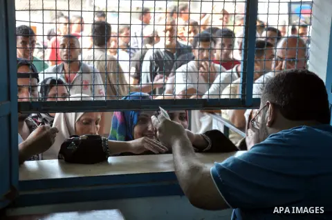 Palestinians wait to receive food aid at a United Nations food distribution centre, in Gaza city on August 17, 2014. Pierre Krähenbühl, the Commissioner General for the UN Relief and Works Agency for Palestine Refugees s...