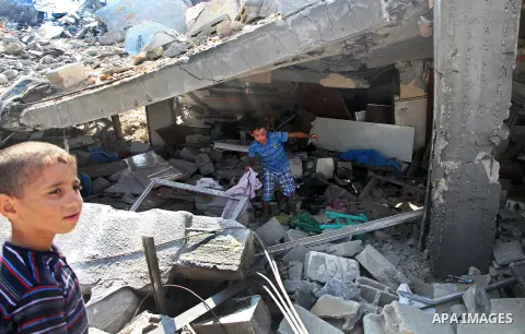 Palestinian children search in their house, which witnesses said was destroyed during the Israeli offensive, in al-Shijaiya district in the east of Gaza city on August 18, 2014. Israeli and Palestinian negotiators in Egy...