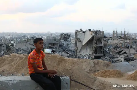 Palestinians walks past buildings destroyed during fighting between Hamas militants and Israel in the Al-Shaaf neighbourhood, in Gaza City, on August 18, 2014.Prime Minister Benjamin Netanyahu warned that Israel will hit...