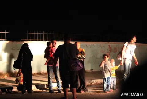 A group of Palestinians carry some of their belonging as they walk past a destroyed home, back to a UN school where many displaced Palestinians are taking refuge, in the Shejaiya neighborhood of Gaza City, on August 18,...