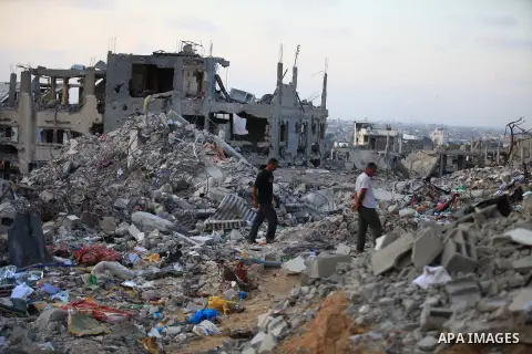 Palestinians walks past buildings destroyed during fighting between Hamas militants and Israel in the Al-Shaaf neighbourhood, in Gaza City, on August 18, 2014.Prime Minister Benjamin Netanyahu warned that Israel will hit...