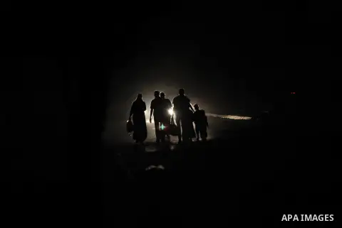 A group of Palestinians carry some of their belonging as they walk past a destroyed home, back to a UN school where many displaced Palestinians are taking refuge, in the Shejaiya neighborhood of Gaza City, on August 18,...