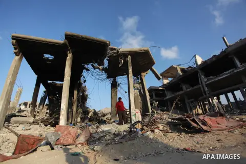 Palestinians walks past buildings destroyed during fighting between Hamas militants and Israel in the Al-Shaaf neighbourhood, in Gaza City, on August 18, 2014.Prime Minister Benjamin Netanyahu warned that Israel will hit...